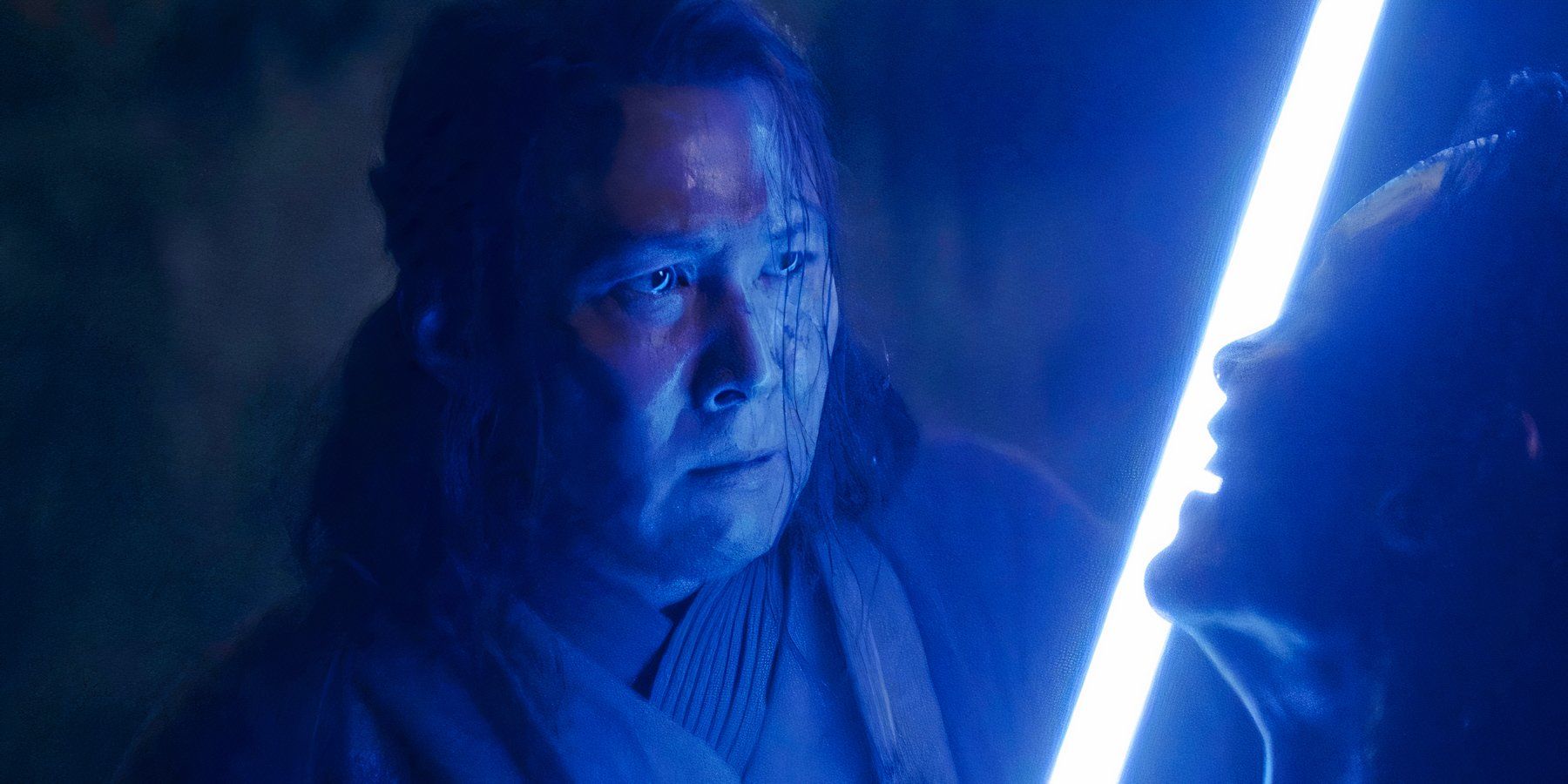 Lee Jung-jae as Sol illuminated by a blue lightsaber in The Acolyte