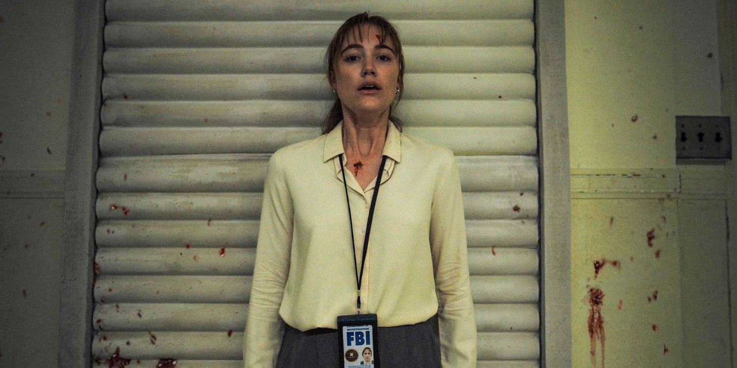 Maika Monroe as Agent Lee Harker stands against a wall in Longlegs