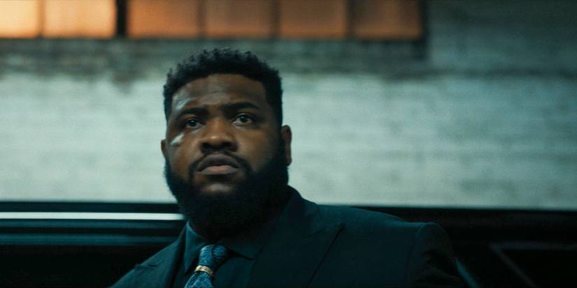 Bunny (Tobi Bamtefa) olhando para Mike em Mayor of Kingstown temporada 3 episódio 7