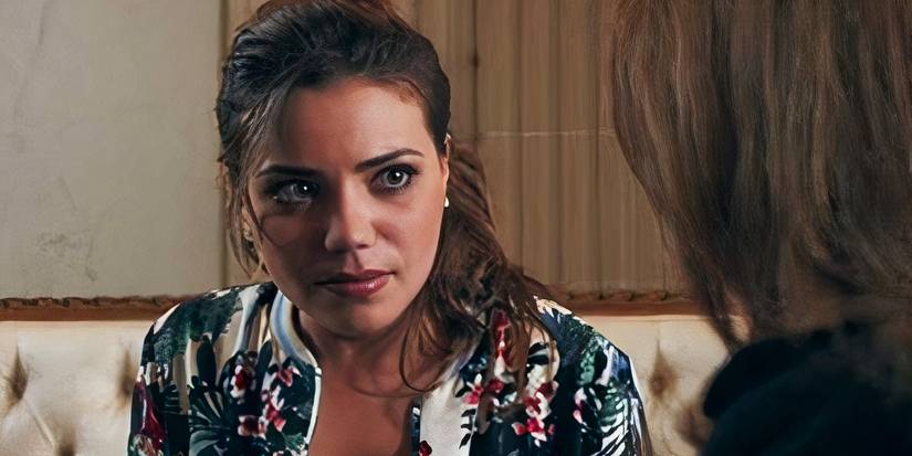 Nassima Benchicou talks to someone while sitting on a couch