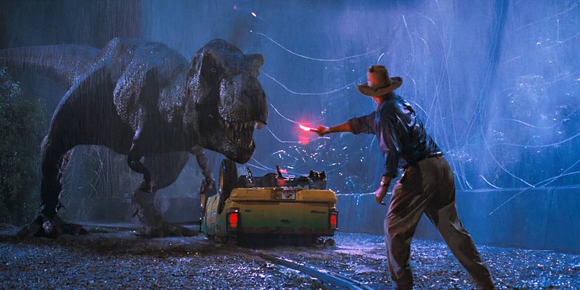 Sam Neill as Alan Grant is waving a flare at a T-rex in Jurassic Park.
