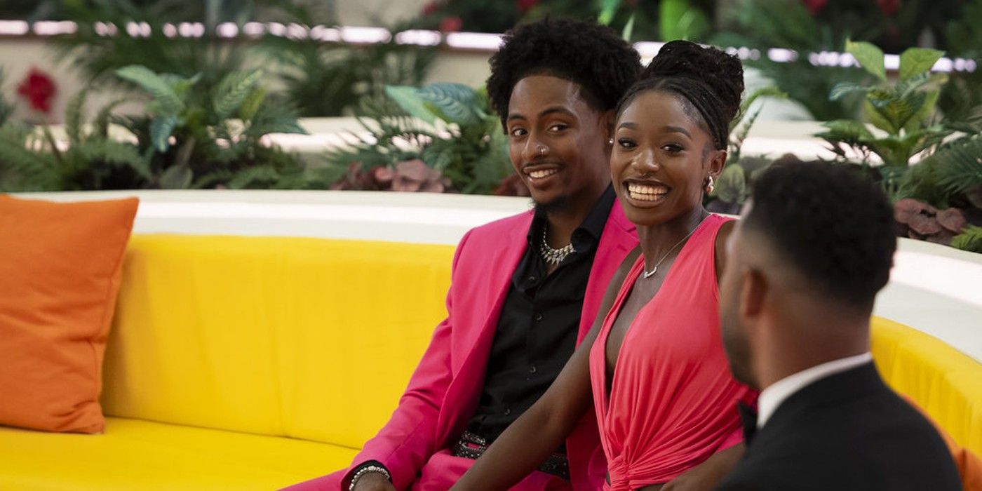 Serena Page & Kordell Beckhamfrom  Love Island USA Season 6 smiling on a couch in matching pink outfits.