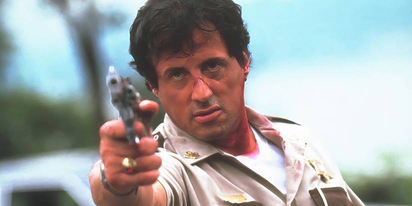 Sylvester Stallone aponta uma arma para alguém em Cop Land