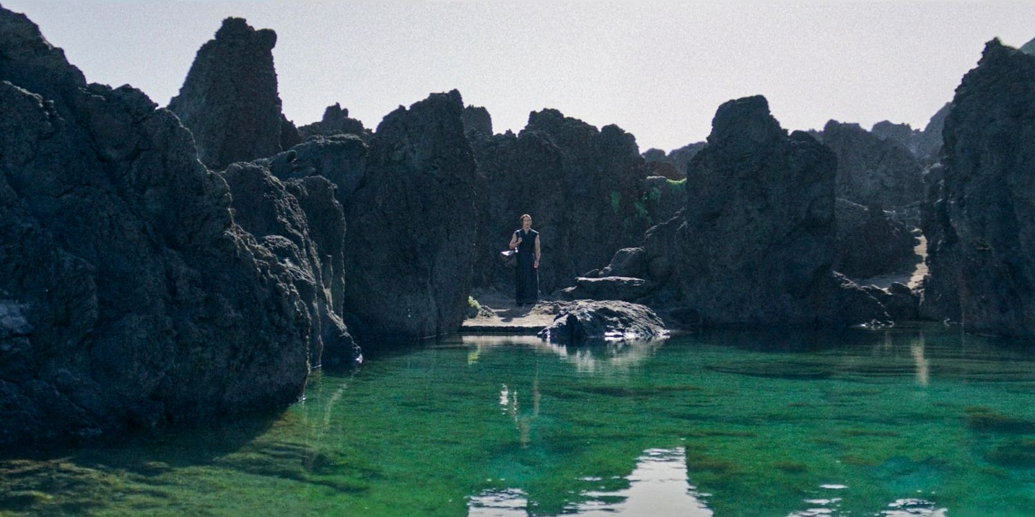 Qimir (Manny Jacinto) standing by the water on the Unknown Planet in The Acolyte season 1 episode 6