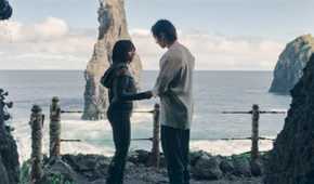 Qimir (Manny Jacinto) and Osha (Amandla Stenberg) standing in front of the water on the Unknown Planet in The Acolyte season 1 episode 6