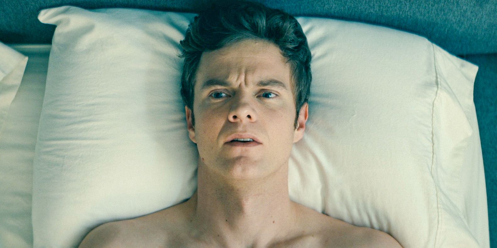 Hughie (Jack Quaid) lying in bed, thoughtful about Starlight's strange behavior in The Boys.