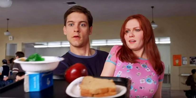 Tobey Maguire as Peter Parker catching food on lunch tray with Kirsten Dunst as Mary Jane in Spider-Man (2002)