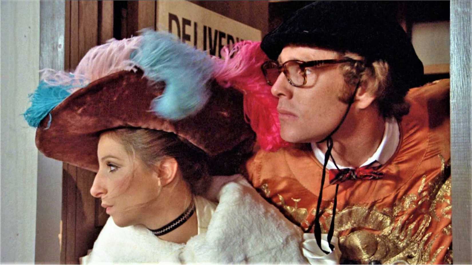 Ryan O'Neal and Barbra Streisand as Howard and Judy looking out a window in What's Up Doc
