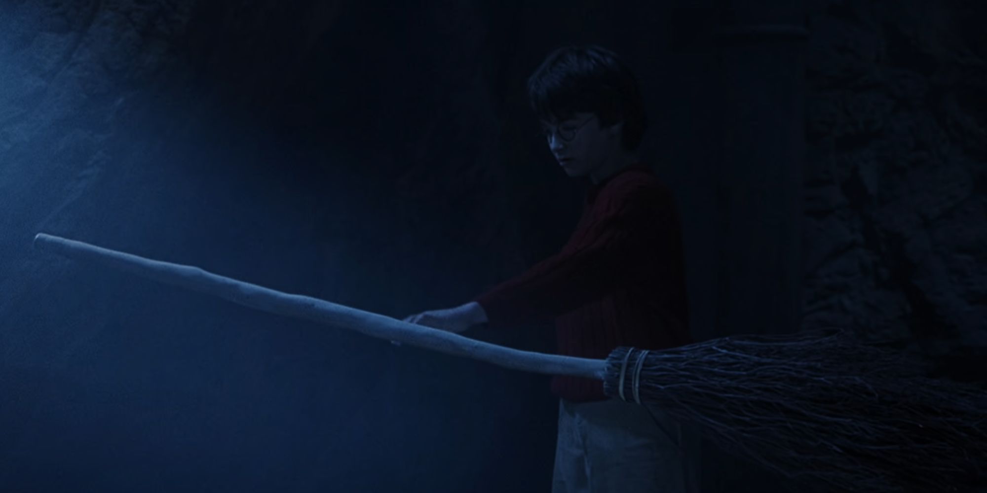 Daniel Radcliffe reaching out to touch a broom in Harry Potter and the Sorcerer's Stone