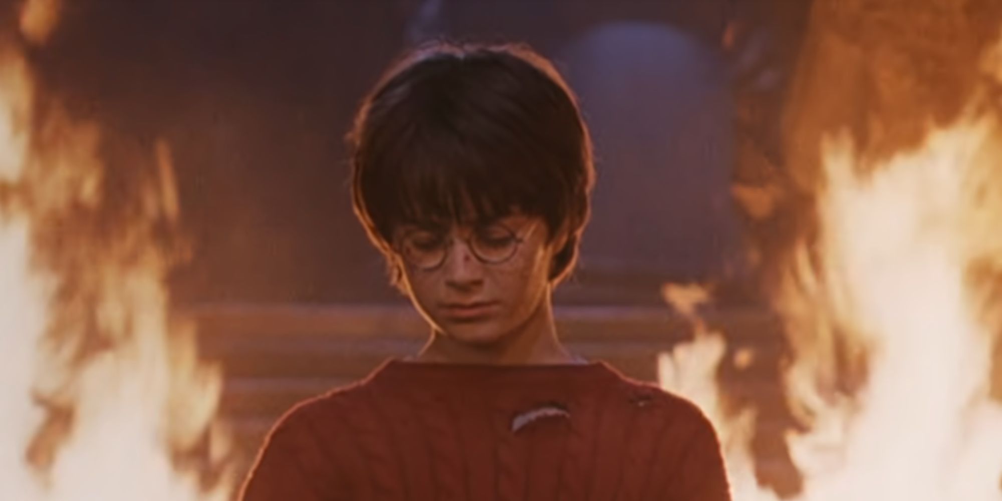 Daniel Radcliffe as Harry Potter looking down in The Sorcerer's Stone