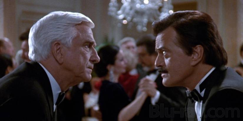 Leslie Nielsen staring down another man in The Naked Gun 2 1/2: The Smell of Fear