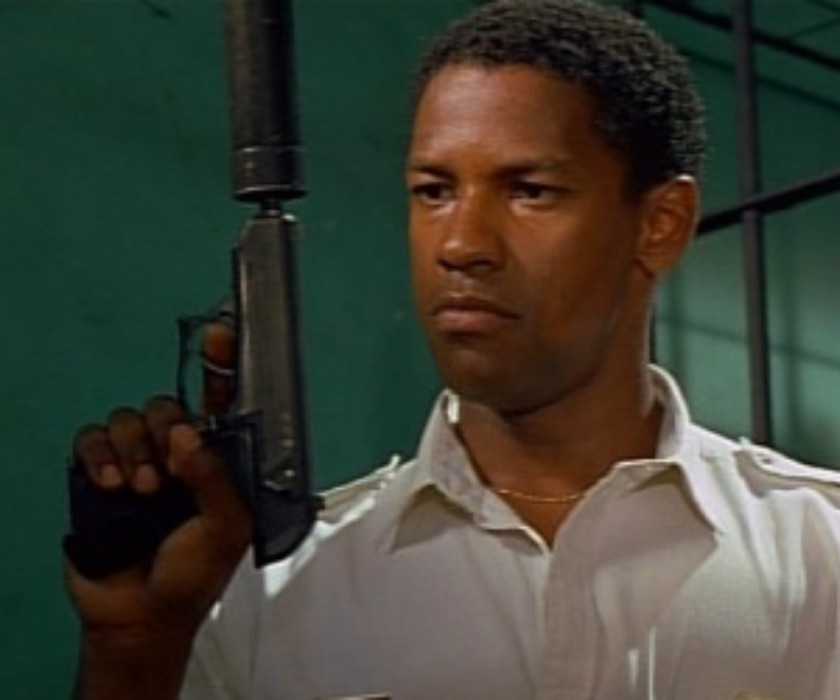 Denzel Washington holding a gun in The Mighty Quinn