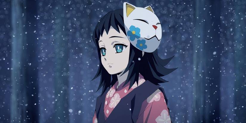 Makomo standing and looking sad in a forest during snowfall with a cat mask on the side of her head.