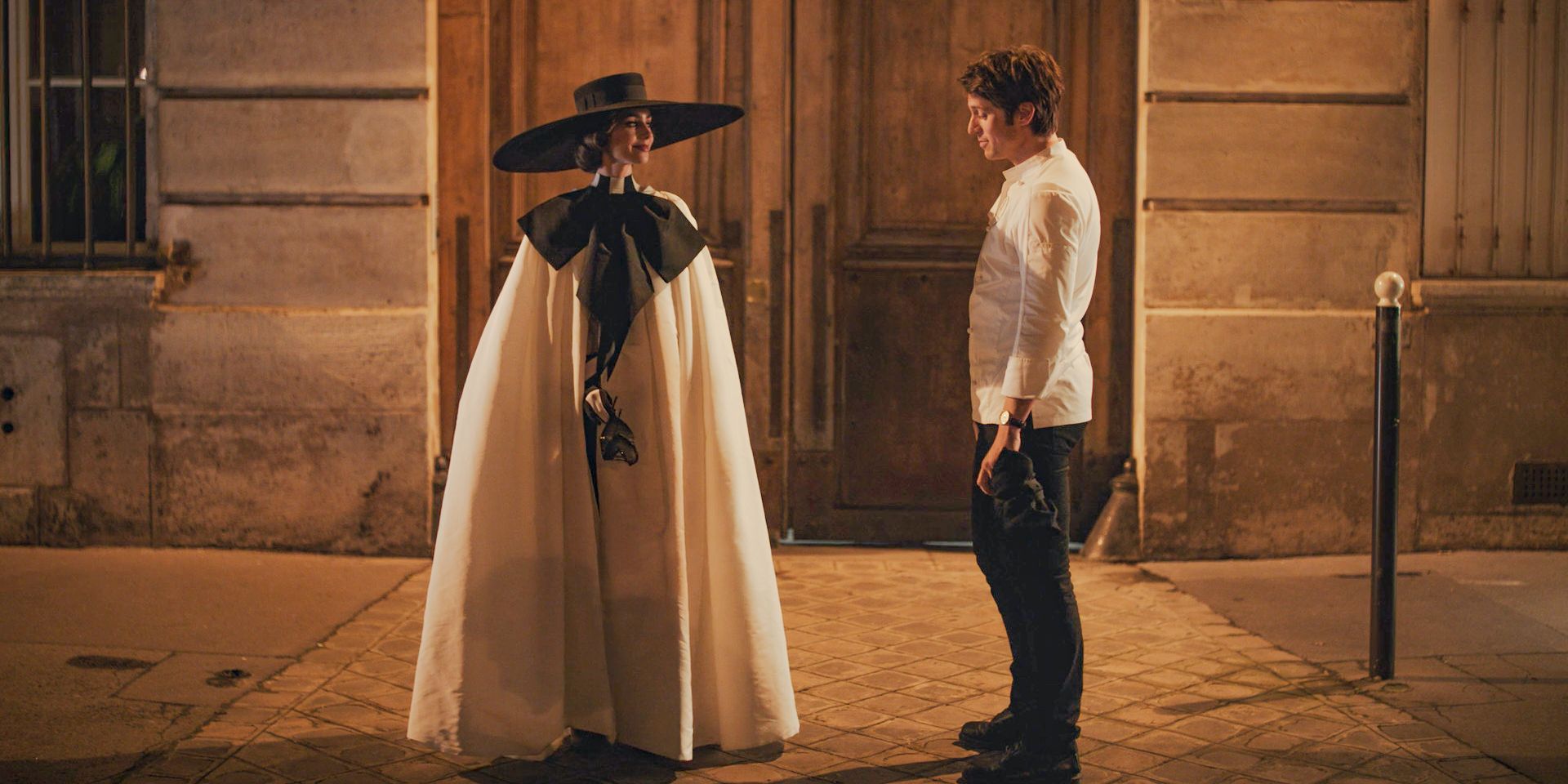 Emily (Lily Collins) in her masquerade ball outfit chatting with Gabriel (Lucas Bravo) in Emily in Paris Season 4