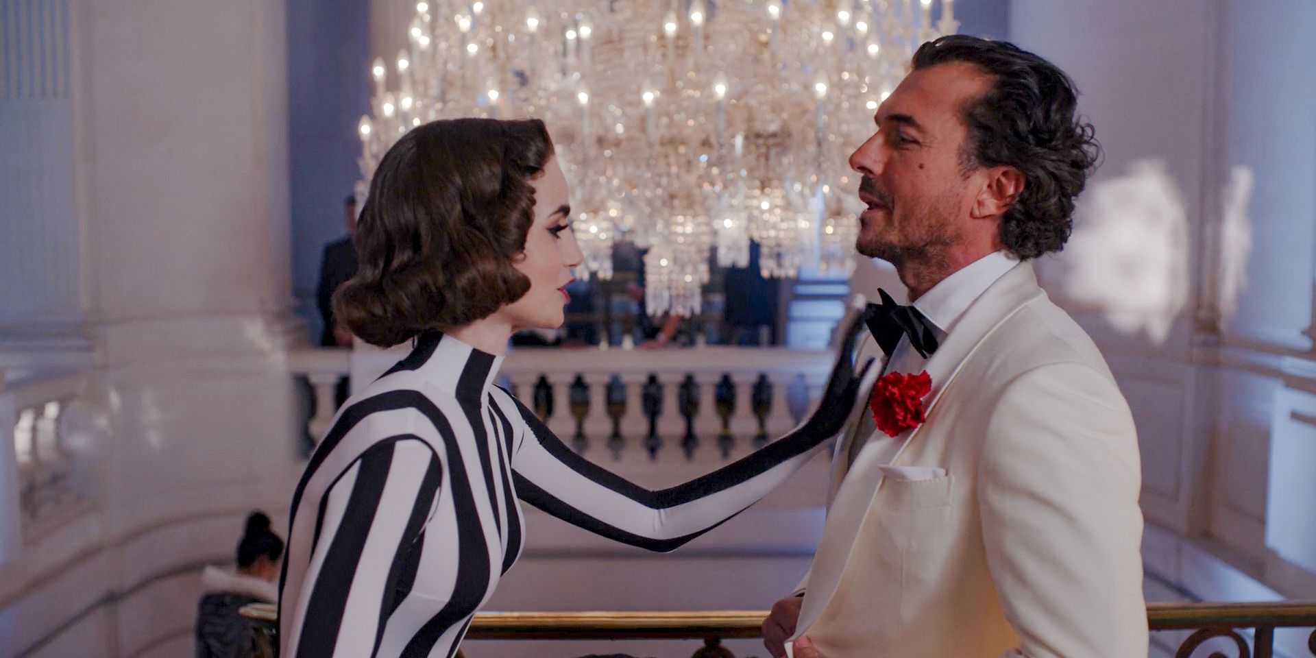 Emily (Lily Collins) adjusts the bow tie of Antoine (William Abadie) at the masked ball in Emily in Paris Season 4