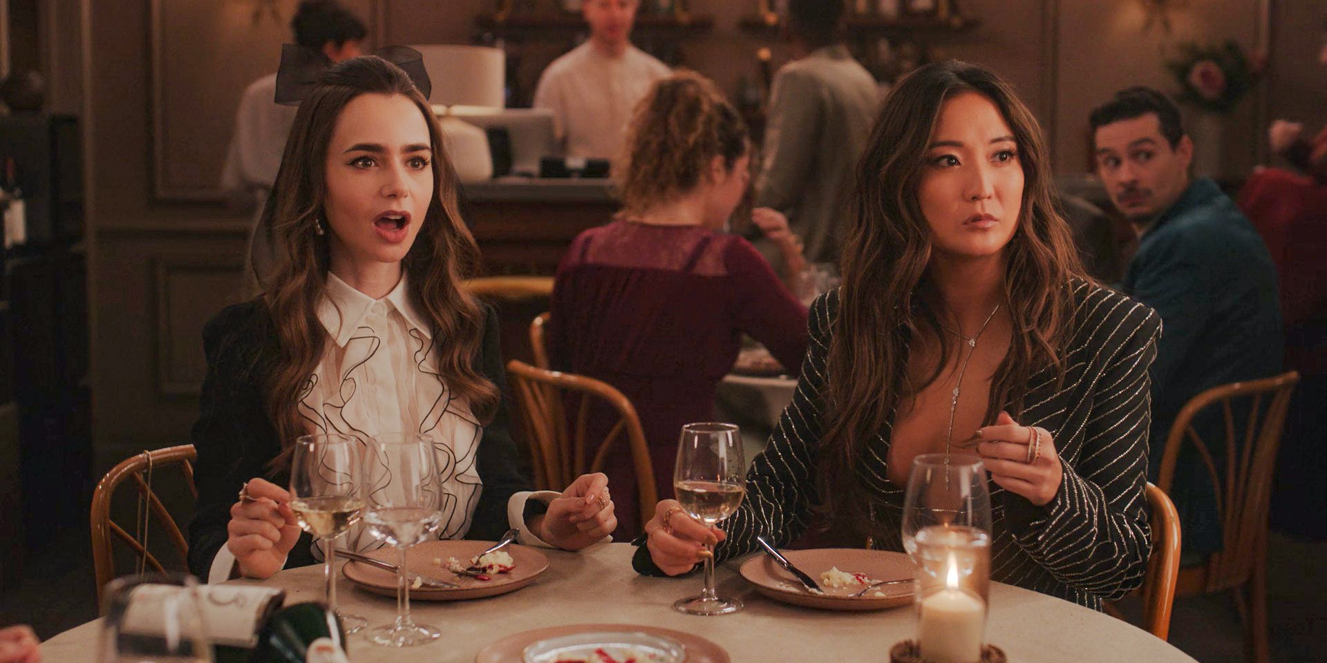 Emily (Lily Collins) and Mindy (Ashley Park) shocked by the visit of a Michelin inspector at Gabriel's restaurant in Emily in Paris Season 4