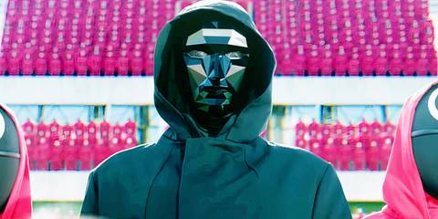 Front Man flanked by guards in an empty stadium in a Squid Game season 2 announcement video