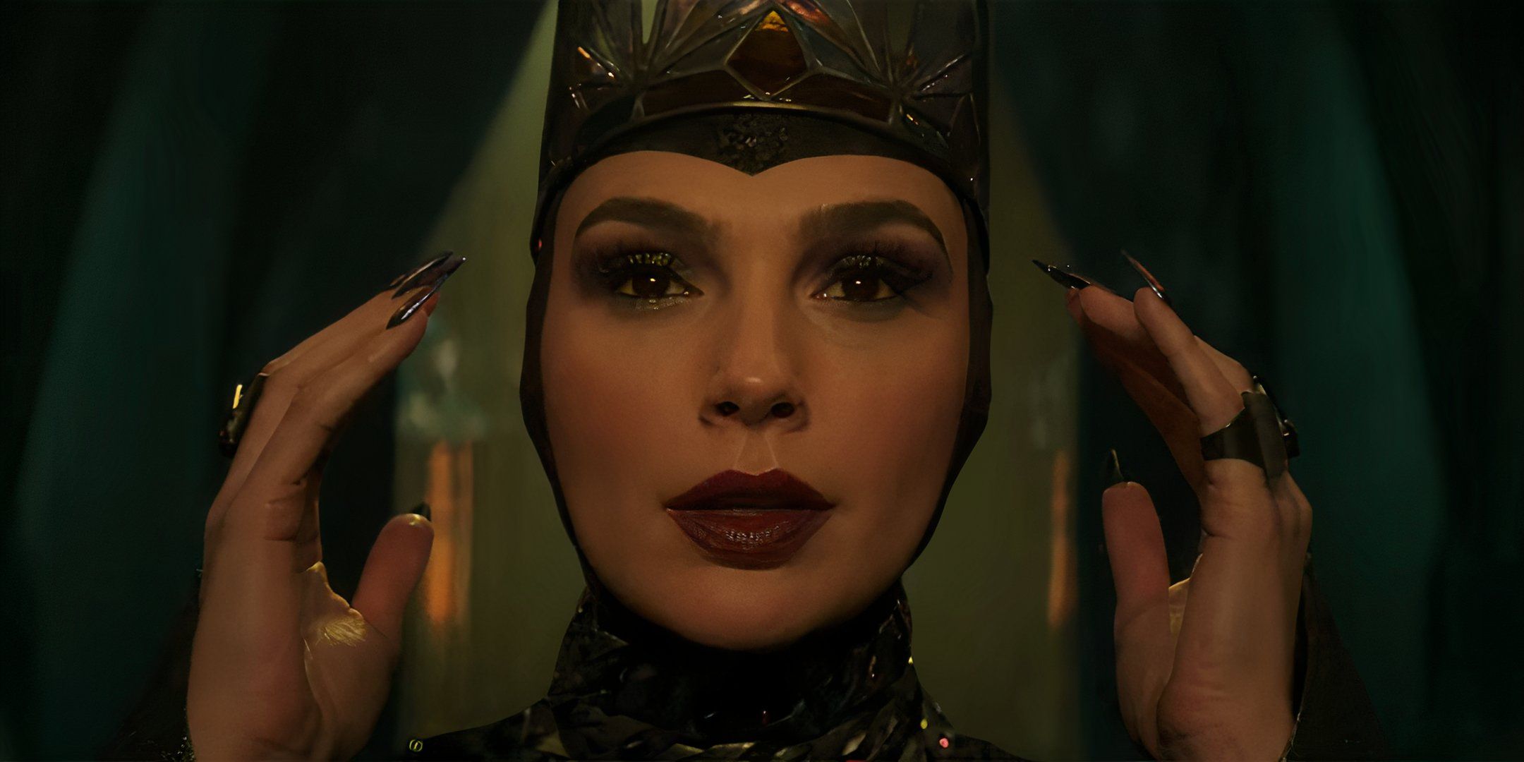 Gal Gadot as the Evil Queen putting on her crown in Snow White