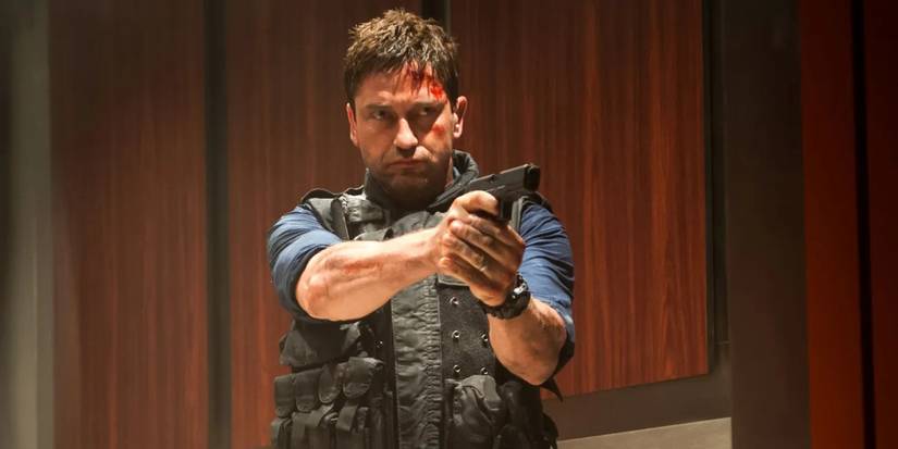 Gerard Butler as a bloodied Mike Banning pointing a gun in Olympus Has Fallen