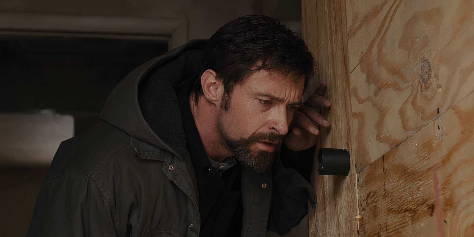 Hugh Jackman as Keller listening against a wall in Prisoners