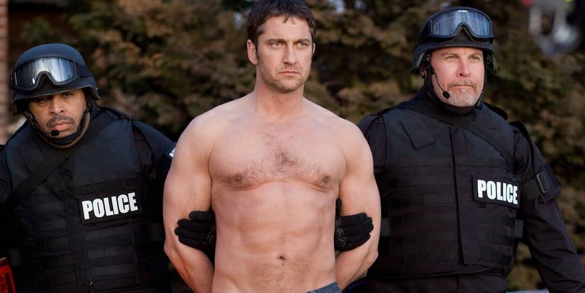 Dois policiais prendem Clyde (Gerard Butler) sem camisa