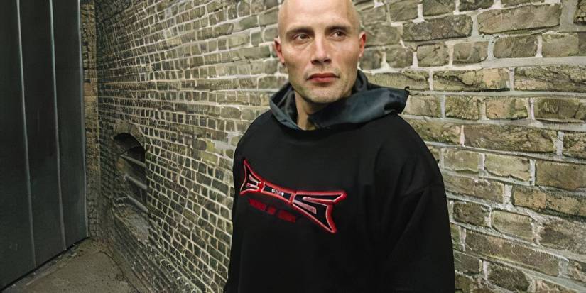 Mads Mikkelsen as Tonny, wearing a hoodie and standing in an alley in Pusher (1996)