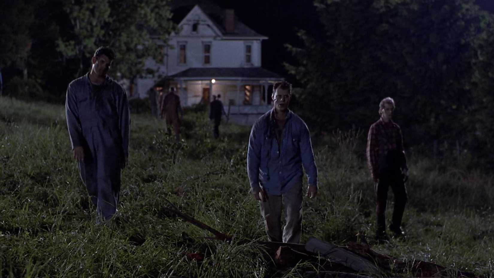 Zumbis caminham por um quintal em Night of the Living Dead (1990).