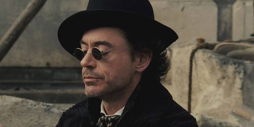 robert downey junior as sherlock holmes wearing sunglasses and a black corduroy coat