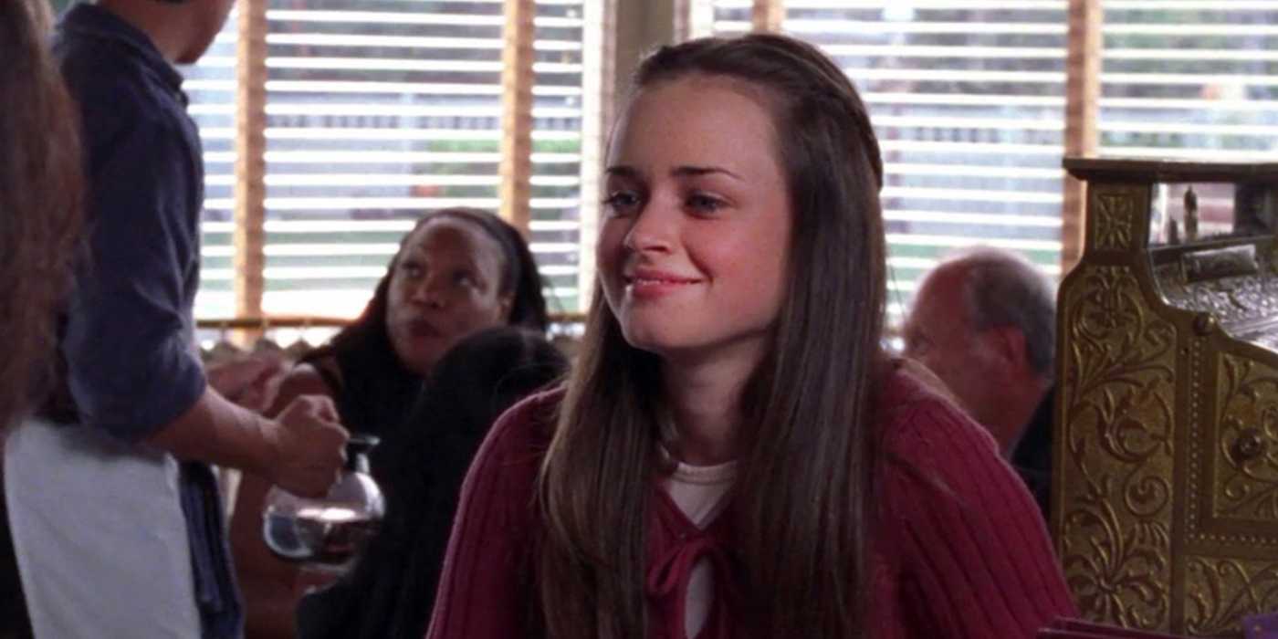 rory smiling in a room full of people in gilmore girls