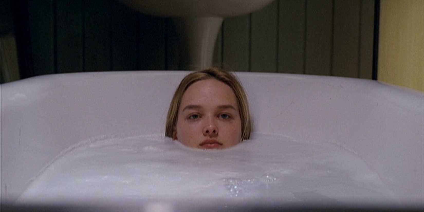 Jess Weixler as Dawn sits in a bath, looking unhappy in Teeth
