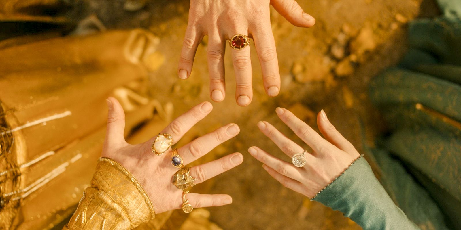 The hands of Círdan, Galadriel, and the High King wielding the Rings of Power in The Lord of the Rings: The Rings of Power Season 2 Episode 1