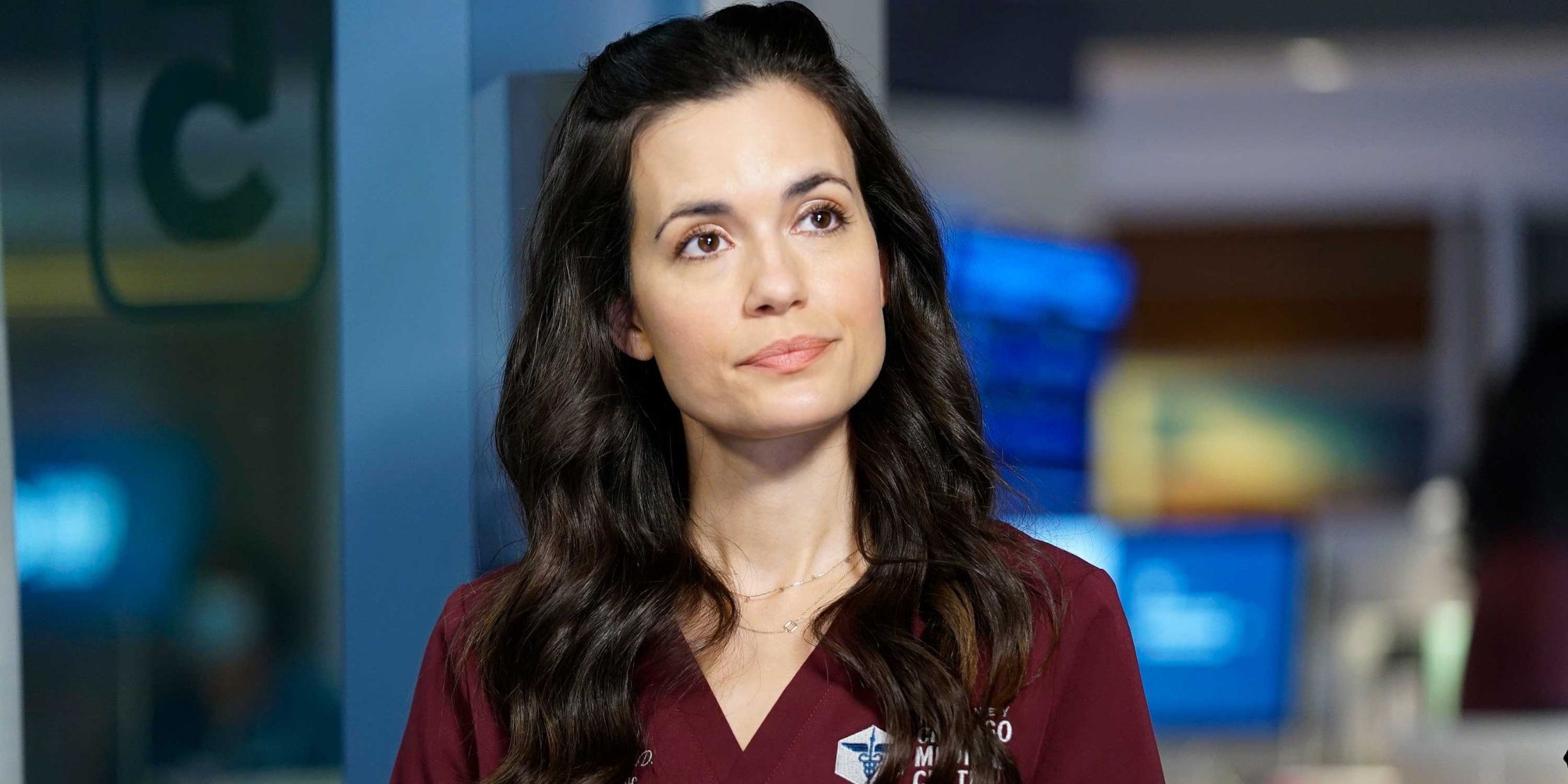 Chicago Med Natalie standing in front of hospital equipment smiling