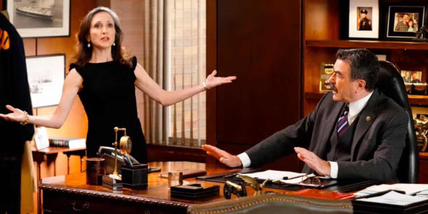 Blue Bloods Frank sitting at his desk holding his hands out while Kelly Peterson makes a point with hers