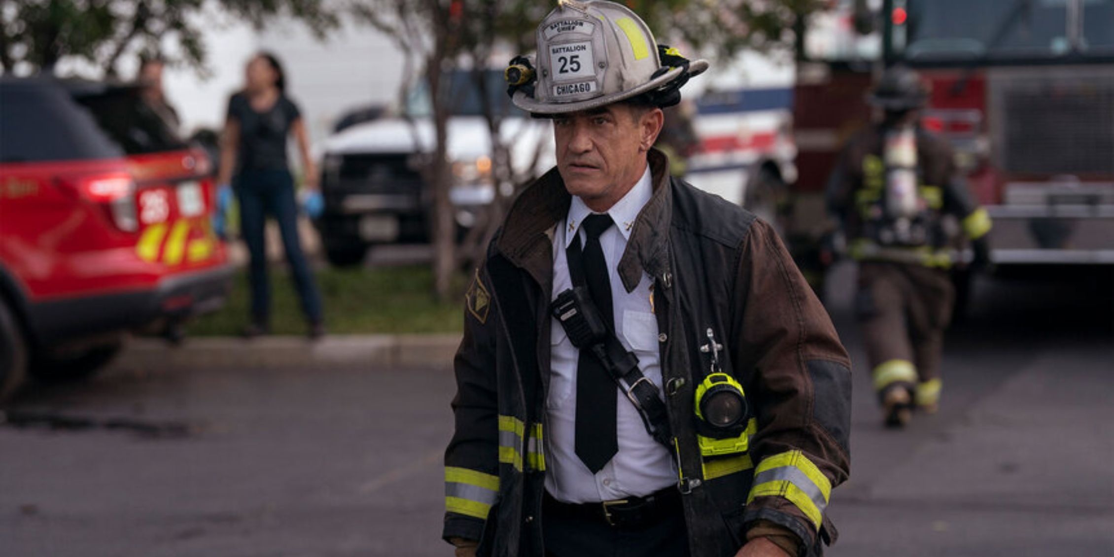 Chicago Fire Pascal crossing the street in fire gear and a tie