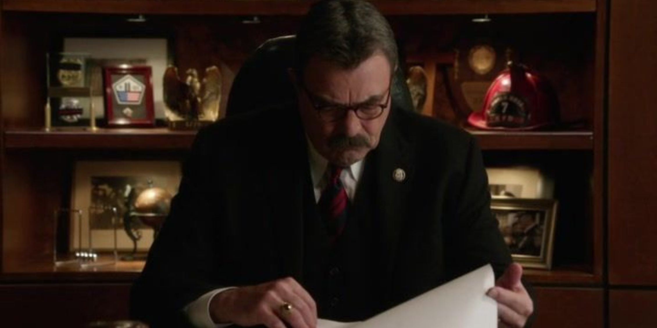 Blue Bloods Frank at his desk reading a report