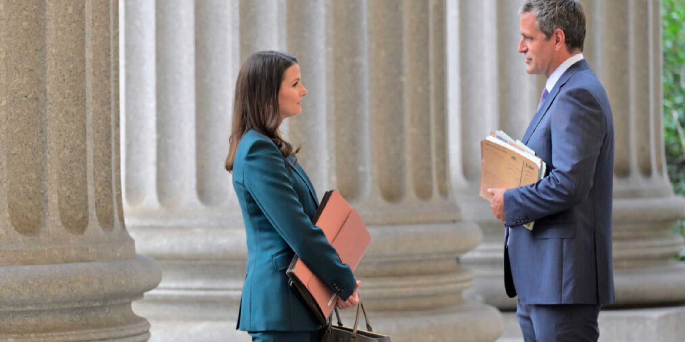 Blue Bloods Jack And Erin holding file folders and facing each other outside the courthouse