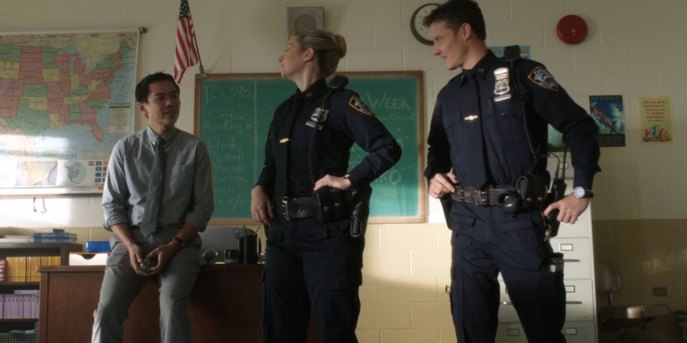 Blue Bloods Jamie And Eddie standing in front of a classroom talking to a teacher