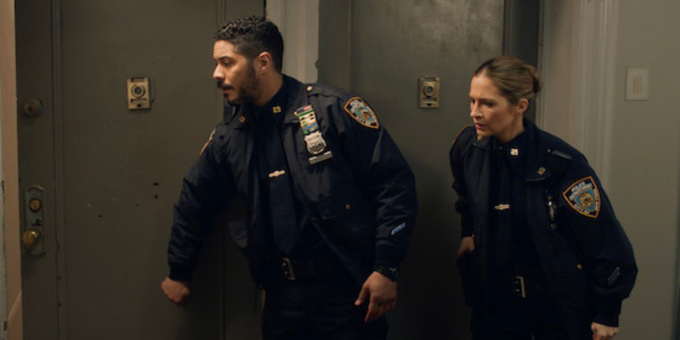 Blue Bloods Badillo and Eddie in uniform outside an open apartment door