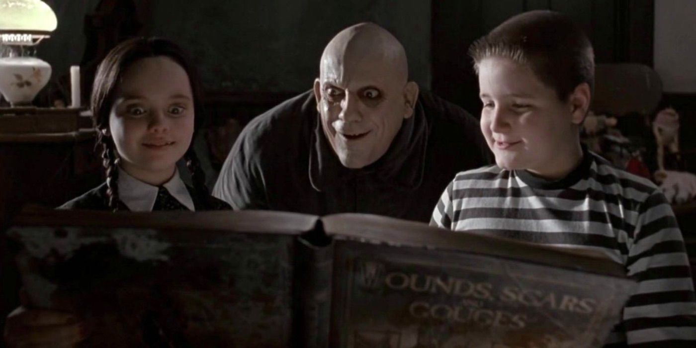 Fester looking at an old book with Wednesday and Pugsley in The Addams Family