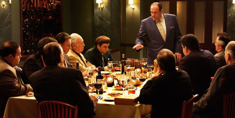 Tony, Silvio, Hesh, Bobby, Paulie et al sit around a dinner table with glasses of red wine in The Sopranos