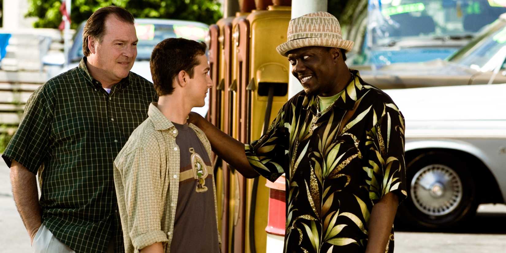 A car salesman (Bernie Mac) put his hands on the shoulder of Sam Witwicky (Shia LaBeouf) in Transformers (2007)