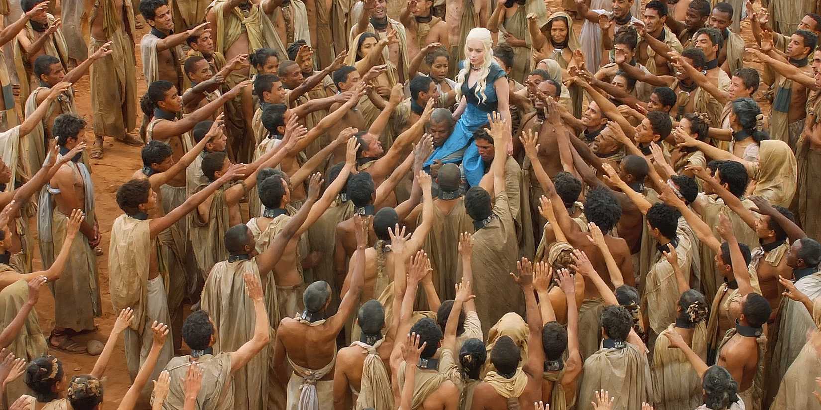 Daenerys (Emilia Clarke) wearing a blue dress, walking among a crowd of people from Yunkai in Game of Thrones season 3's finale