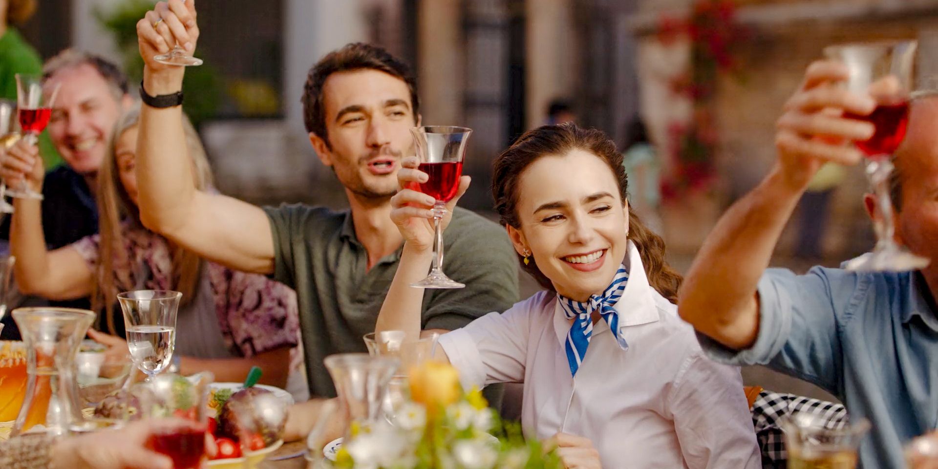 Emily (Lily Collins) and Marcello (Eugenio Franceschini) toasting at a birthday party in Solitano in Emily in Paris Season 4 Episode 10