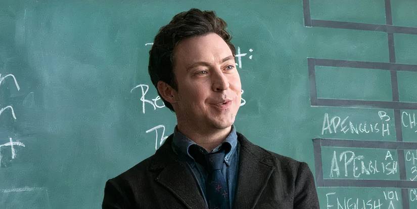 Evan smiles while talking in front of the chalkboard in English Teacher