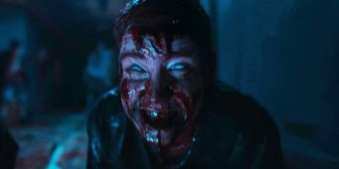 Deadite Danny smiling while covered in blood in Evil Dead Rise