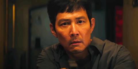 Gi-hun holding a gun and looking shocked in Squid Game season 2