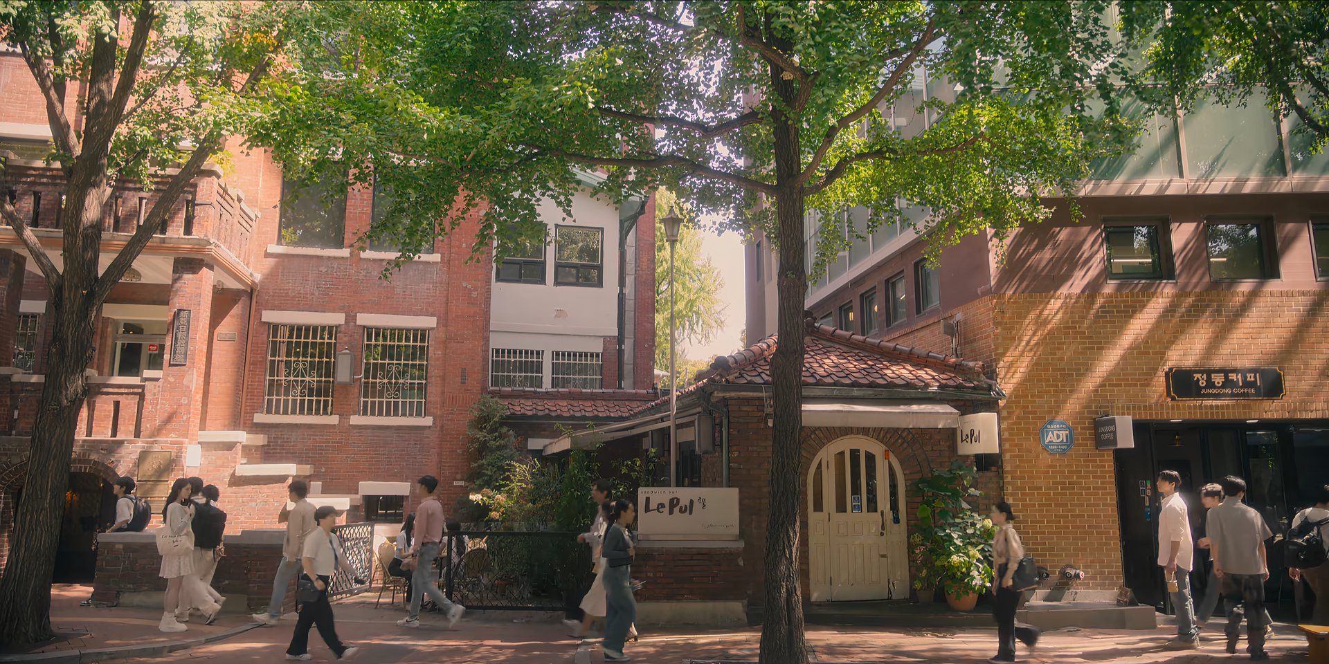 Yoon Chae-ok and Jang Tae-sang stand opposite each other on a busy street in Gyeongseong Creature