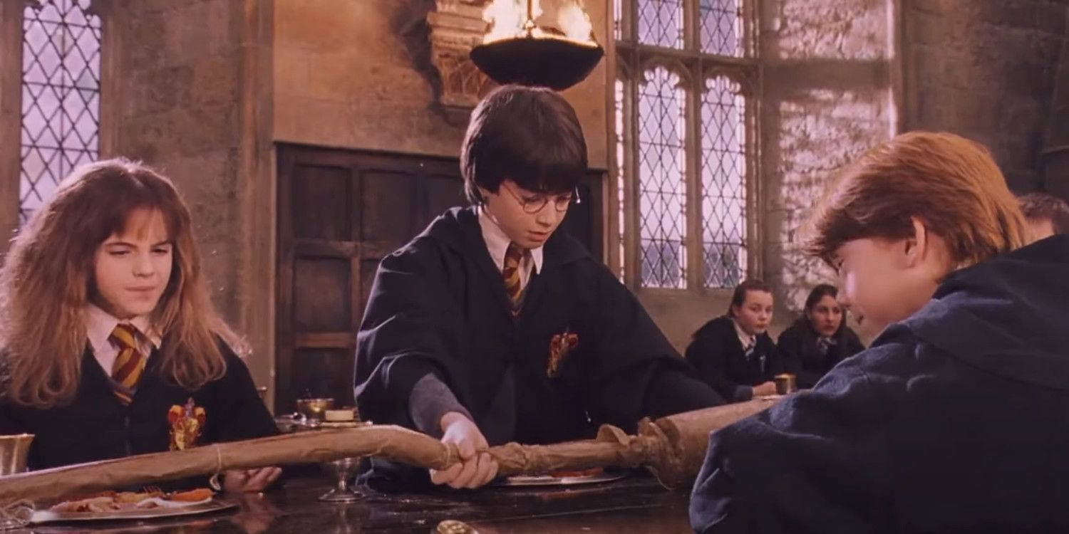 Daniel Radcliffe as Harry Potter looking at his Nimbus 2000 broomstick with Hermione and Ron in Sorcerer's Stone