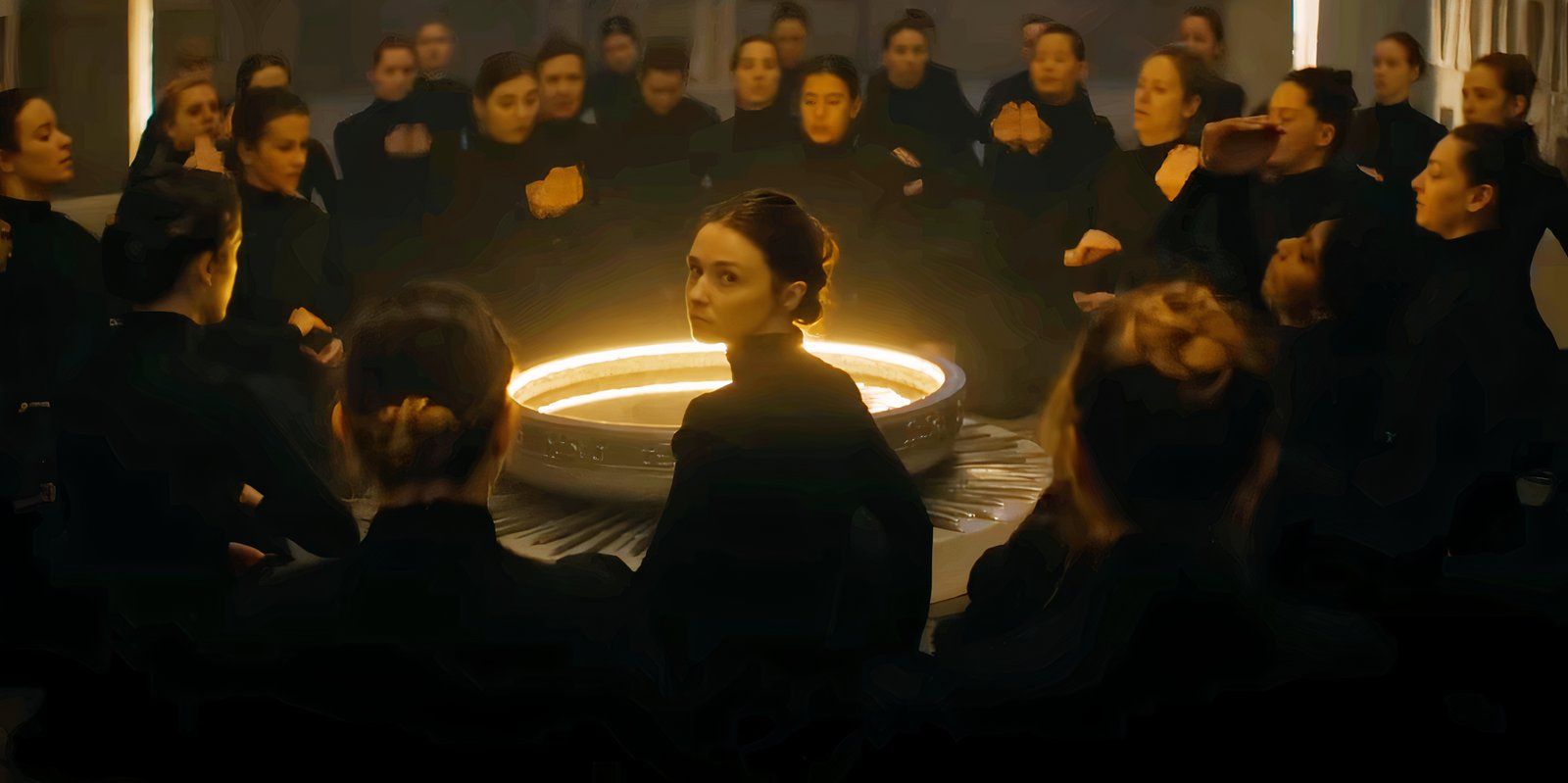 Jessica Barden looking over her shoulder while surrounded by women in black cloaks in Dune Prophecy