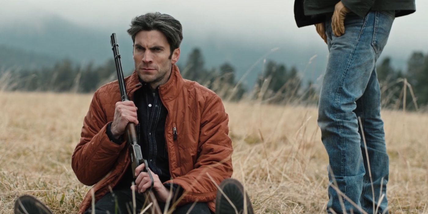 John (Kevin Costner) standing over Jamie (Wes Bentley) as he holds a gun in Yellowstone.